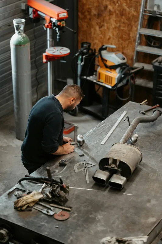 Professional technician working on exhaust and muffler repair at API Auto Repair in Elkridge, MD